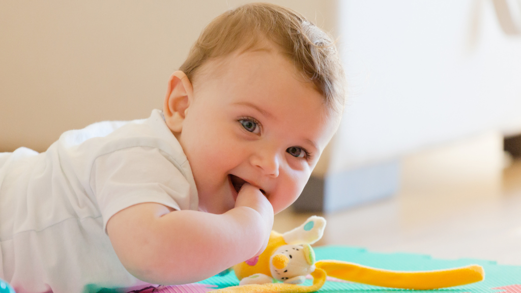 Bebé feliz por jugar en el suelo.